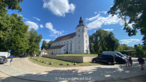 Von außen lässt sich der Aufbau der Johanniterkirche gut erkennen: der schmalere Chor und das breitere Kirchenschiff. Direkt daneben befindet sich die Fürstengruft – Ruhestätte der Strelitzer Fürsten und damit noch einmal ein ganz eigenes Stück Mirower Geschichte.