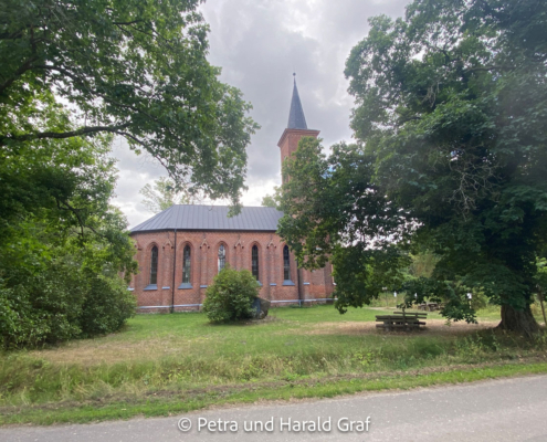 Die St.-Johannis-Kirche von der Seite: ein neugotischer Backsteinbau mit polygonalem Chorschluss und vorgestelltem Westturm. Der heutige Kirchenbau entstand ab 1844 und wurde 1847 eingeweiht.